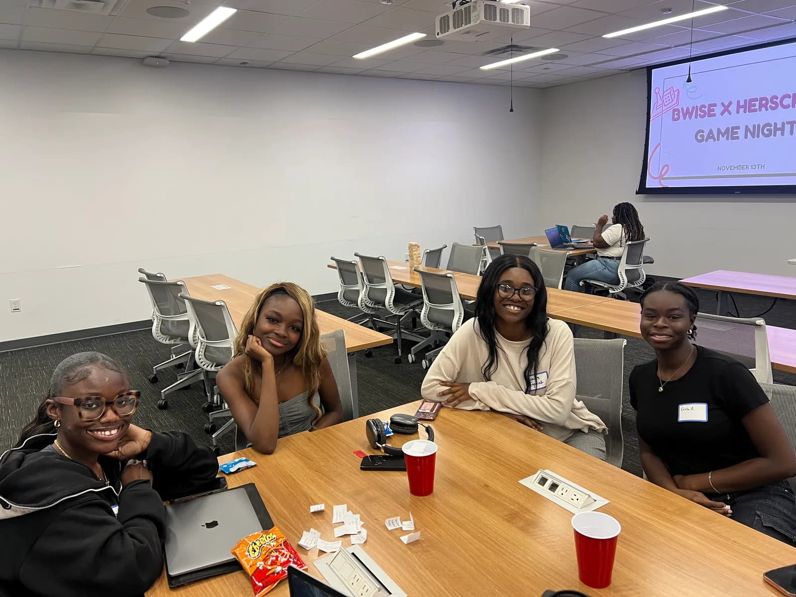 Four members seated around a table at the BWISE and HerScript game night