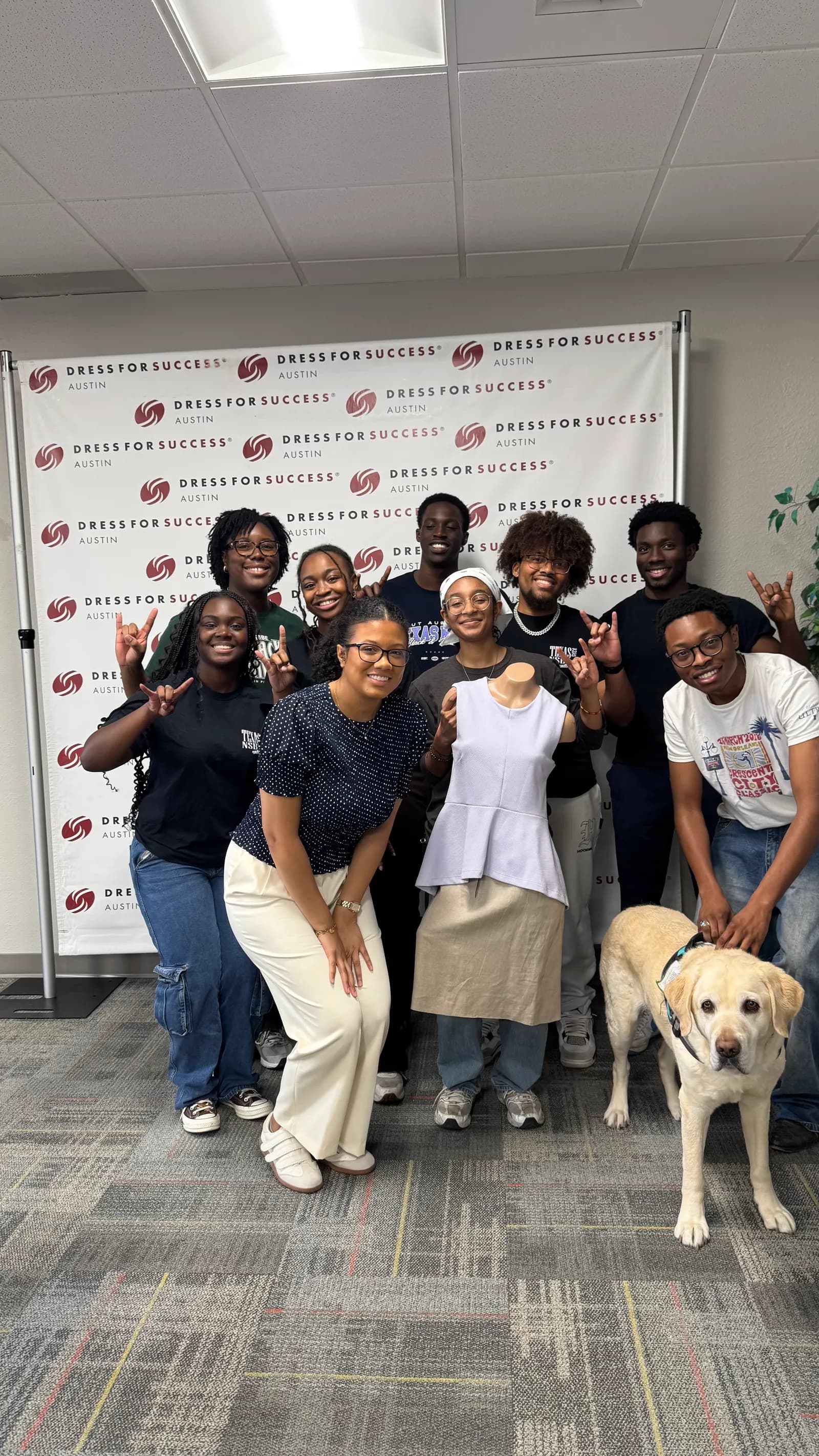 NSBE volunteers throwing Hook 'em Horns at the Dress for Success Austin office