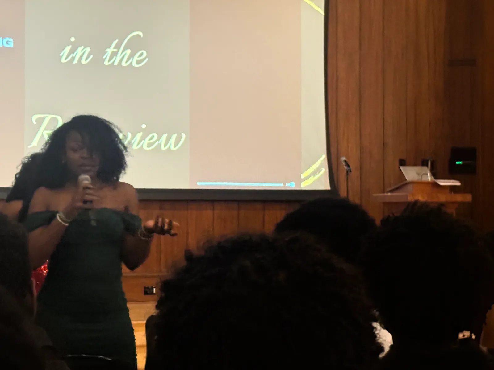 A performer singing into a microphone on stage at the chapter gala